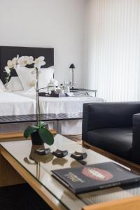 a living room with a bed and a coffee table with a flower at Hotel Canaleta Heras in Espolla