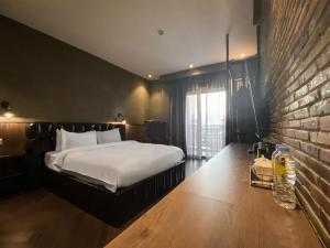 a bedroom with a bed and a brick wall at CHECK inn Phnom Penh BKK1 in Phnom Penh