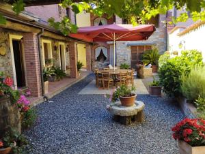 een patio met een tafel en een parasol bij La cascina di Anna in Beverino