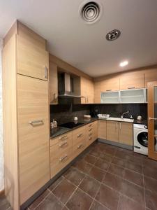 uma grande cozinha com armários e electrodomésticos de madeira em CASA NEUS, casa junto a Barcelona em Sant Feliu de Llobregat
