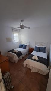 - une chambre avec 2 lits et un ventilateur de plafond dans l'établissement El Madroño de la Encantada, à Cordoue