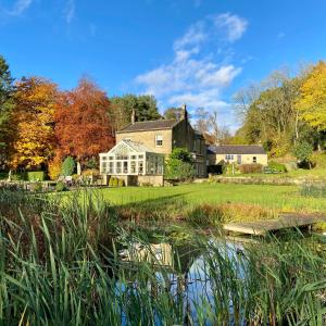 a large house with a pond in front of it at Grove House Levisham in Pickering