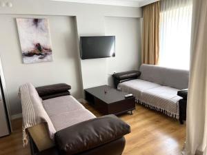 a living room with a couch and a tv at Seaside Serenity.Kusadasi,Turkey in Kusadası