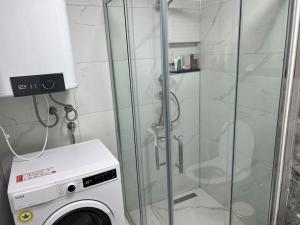 a washing machine in a bathroom with a glass shower at Seaside Serenity.Kusadasi,Turkey in Kusadası