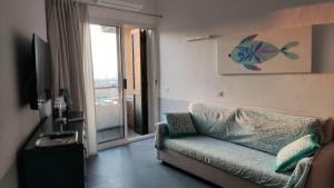 a living room with a couch and a sliding glass door at Bellavista Punta Ala in Punta Ala