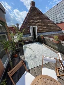 an outdoor patio with chairs and a tile roof at Julius Groningen in Groningen