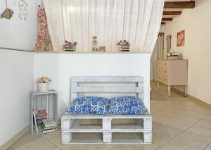 a bedroom with a bed with blue and white pillows at Mareantico Shabby Apartment in Sampieri
