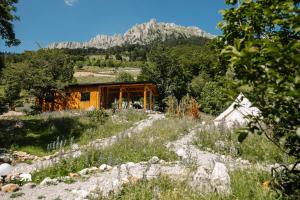 a house in a field with a mountain in the background at Ursa Camp Mountain Glamping in Gornje Lipovo