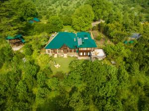 Ramgarh Heritage Villa, Manali, amã Stays & Trails في مانالي: اطلالة جوية على بيت كبير بسقف أخضر