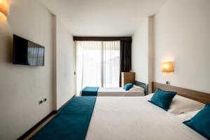 Postel nebo postele na pokoji v ubytování Hotel Cristallo