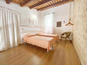 a bedroom with two beds and a chair at Mareantico Shabby Apartment in Sampieri