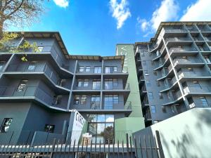 ein Apartmenthaus mit einem Zaun davor in der Unterkunft Circa Aparthotel by Totalstay in Pretoria