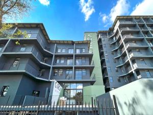 un edificio de apartamentos con una valla delante en Circa Aparthotel by Totalstay, en Pretoria