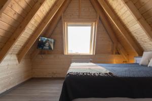 a bedroom with a bed in a attic with a window at MP39 - Strandvogt 2 Komfort in Dorum Neufeld