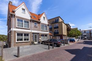 a house with a car parked in front of it at Bed & Breakfast Huys aan zee in Domburg