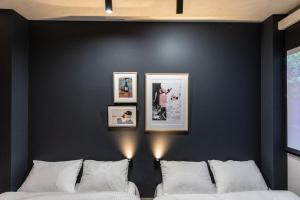 two beds against a black wall with pictures on it at trive ozone2 バンテリンドーム ナゴヤ近く 大曽根駅 徒歩3分 in Yadachō