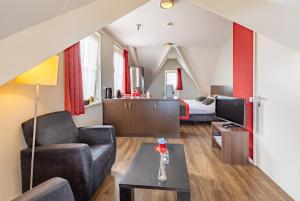 a living room with a couch and a room with a bed at Bed & Breakfast Huys aan zee in Domburg