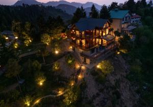 卡纳塔尔Avalon Cottages, Kanatal by Leisure Hotels的夜晚,在空中欣赏大房子的灯光