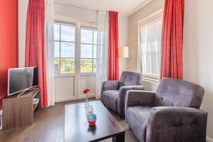 - un salon avec deux chaises et une télévision dans l'établissement Bed & Breakfast Huys aan zee, à Domburg
