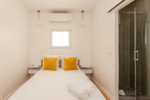 a bedroom with a bed with yellow pillows and a shower at 1 BDR Bourse -Opera with AC in Paris