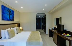 een hotelkamer met een groot bed en een televisie bij My Ella Bodrum Resort & Spa in Mugla