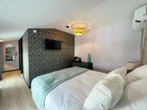 sypialnia z białym łóżkiem ze ścianą w obiekcie Le240b #4 w mieście Saint-Mard