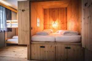 a bedroom with a bed in a wooden cabin at Tauernlust Outdoor & Relax in Mallnitz
