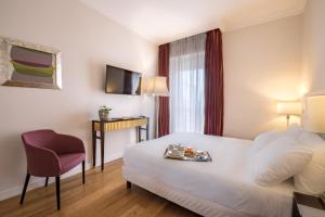 a hotel room with a bed and a chair at Sina Maria Luigia in Parma