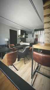 uma sala de jantar com mesas e cadeiras num quarto em Le240b #4 em Saint-Mard