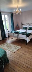a bedroom with a large bed and a chandelier at Moulin des Prés - 15 couchages - 1h15 des Jeux Olympiques PARIS 2024 in Croissy-sur-Celle