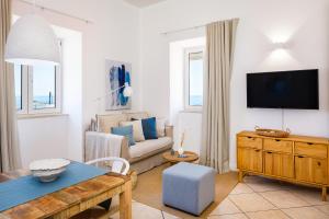 a living room with a couch and a tv at CASA 4YOU in Carvoeiro