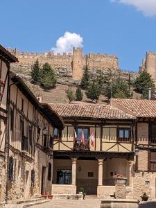 two flags on a building with a castle in the background at Montelobos 