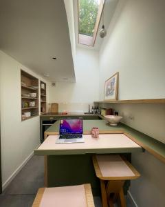 a laptop computer sitting on a desk in a kitchen at Entire Home on Victoria Park in London