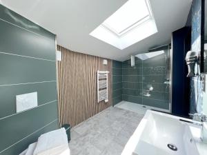 ein Badezimmer mit einem Waschbecken und einer Dusche mit einem Dachfenster in der Unterkunft Le240b #3 in Saint-Mard