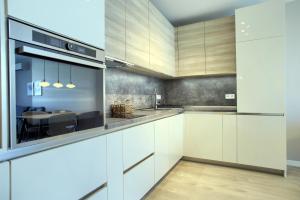 uma cozinha com armários brancos e uma sala de jantar em Anel apartment em St. Constantine and Helena