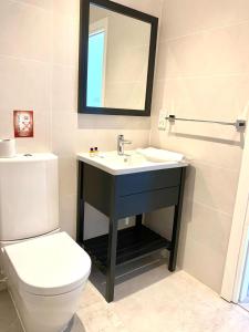 a bathroom with a sink and a toilet and a mirror at Aphrodite Beachfront Resort in Ghaziveran