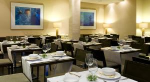 a dining room with tables and chairs with glasses at Hotel Playa Calera in Valle Gran Rey