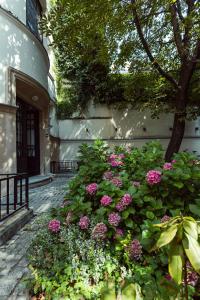 a bush of pink flowers in front of a building at Jana Apartments in Kraków