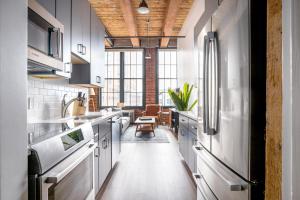 a kitchen with white cabinets and a large window at Bright Fort Point Studio w WD in Unit BOS-260 in Boston