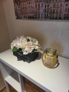 un jarrón de flores y una vela sobre una mesa en Apartamento acolhedor Oeiras, en Barcarena