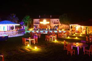 a group of tables and chairs in a yard at night at İksirci Baba Hotel in Oludeniz