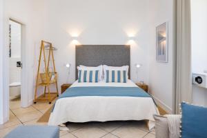 ein Schlafzimmer mit einem großen Bett mit blauen und weißen Kissen in der Unterkunft CASA 4YOU in Carvoeiro