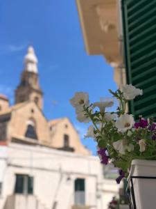 a vase with flowers in front of a building at DIMORA ELIVA in Monopoli
