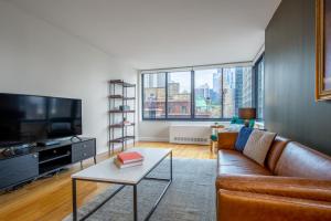 a living room with a couch and a tv at Midtown 1BR w Pool Gym Parking nr Times Sq NYC-378 in New York