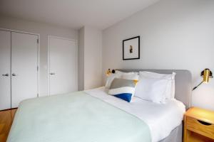 a bedroom with a large white bed with white pillows at Midtown 1BR w Pool Gym Parking nr Times Sq NYC-378 in New York