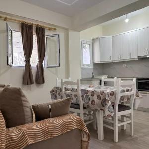 Vila Zisi Himare في هيماري: مطبخ مع طاولة وكراسي في غرفة