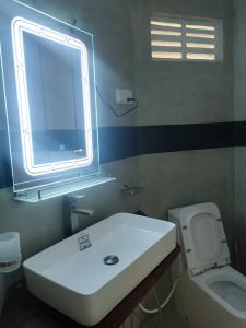 een badkamer met een wastafel, een toilet en een raam bij Shine Breeze villa in Weligama