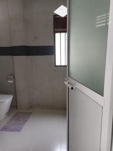 a bathroom with a toilet and a window at Shine Breeze villa in Weligama