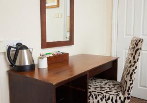 een houten bureau met een spiegel en een stoel bij The Bell Hotel Woburn By Greene King Inns in Woburn