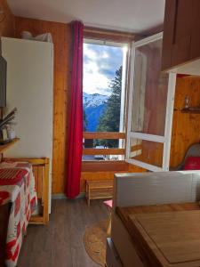 1 dormitorio con ventana y vistas a la montaña en Le petit Nid Rouge, en Ustou